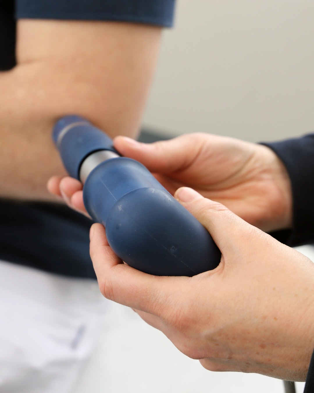 Un thérapeute applique un appareil à ondes de choc sur la zone du tendon d’Achille, près du talon.